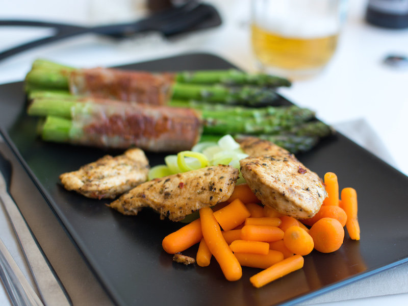 Grilled pepper-crusted chicken served with grilled asparagus and steamed carrots.